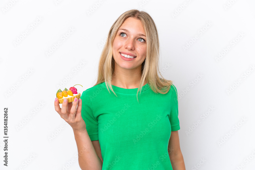 Young caucasian woman holding a tartlet isolated on white background thinking an idea while looking up Young caucasian woman holding a tartlet isolated on white background thinking an idea while looking up