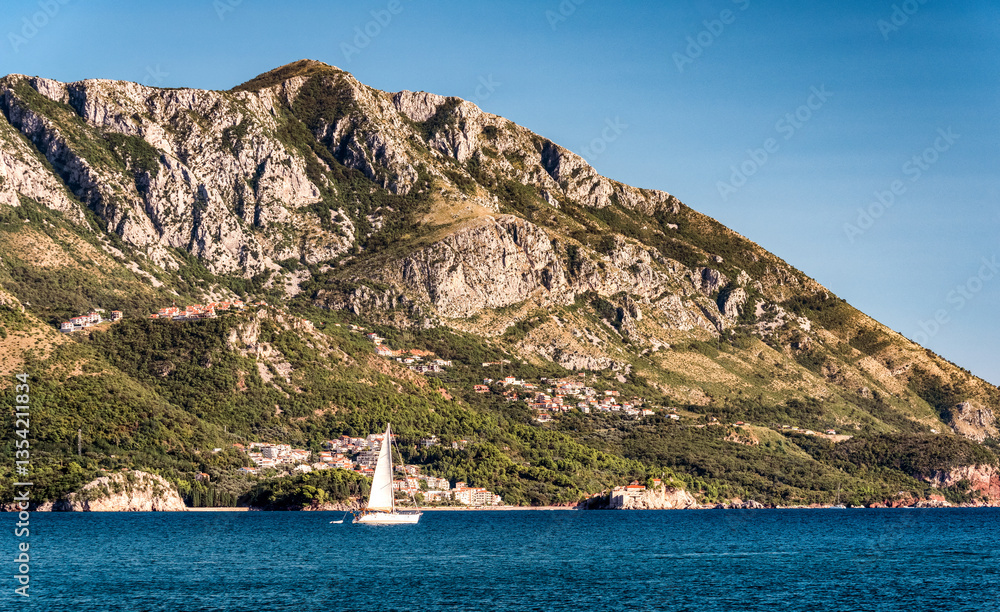 Sailboat floating on the Adriatic Sea in Montenegro. Saint Setafan Island in the background