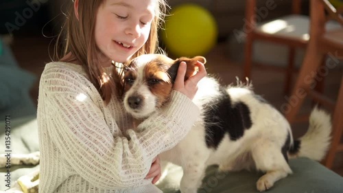 7 year old girl hugs cute little dog