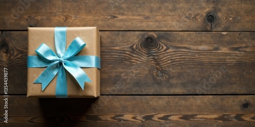 A thoughtfully wrapped gift with a light blue ribbon sits on a rustic wooden surface, ready for a special occasion.