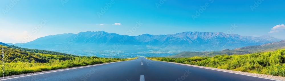 Obraz premium An empty road leading to a mountain range under a clear blue sky, with vibrant greenery on both sides