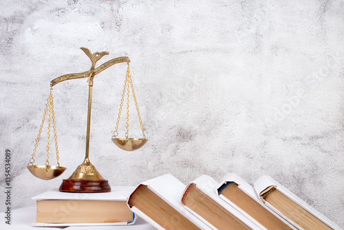 Law concept - Open law book, Judge's gavel, scales, Themis statue on table in a courtroom or law enforcement office. Wooden table, gray concrete background.
