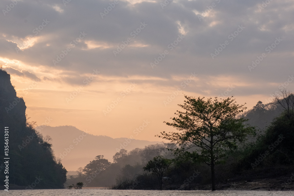 Obraz premium Misty Lake at Sunrise with Mountain Silhouette