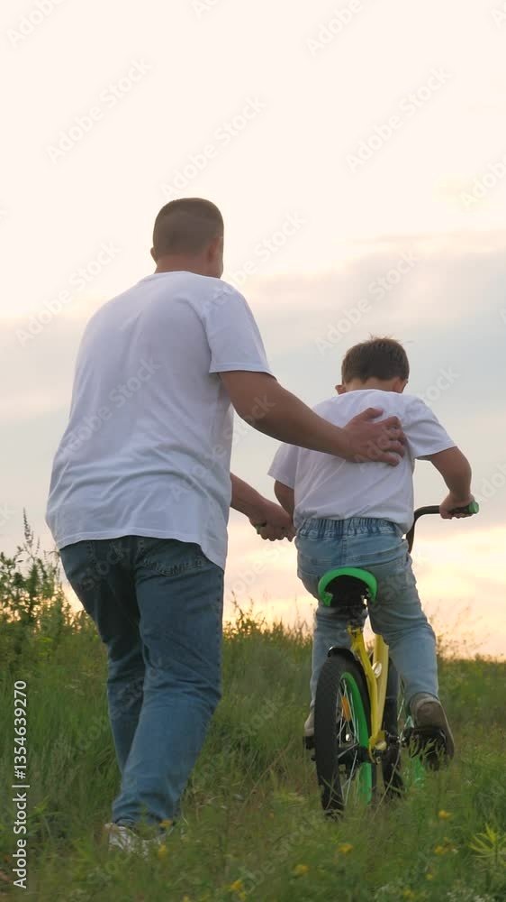 Man helping child ride bike. sky cloudy sun setting. happy family, father run holding child bike, childhood bike, childhood dad, dad son, childhood dream riding dad, picnic nature, vacation holiday