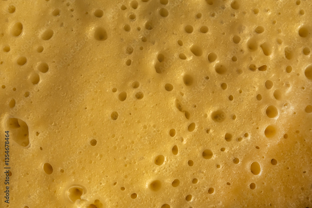 Surface Of Fried Pancake Dough With Tiny Holes. Yellow Background Of Baked Omelette Dough. Fresh Pancake Batter. Surface Of Fried Pancake Dough With Tiny Holes. Yellow Background Of Baked Omelette Dough. Fresh Pancake Batter.