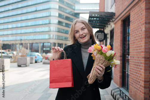 Obraz na płótnie Happy young lady with shopping bag holding a bouquet of yellow tulips, for spring holiday celebrating mother's day or women's day. Woman's Day sale, discount or promotion concept. w salonie