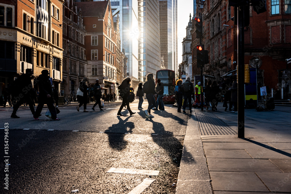 People crossing the street in London at sunset with long shadows