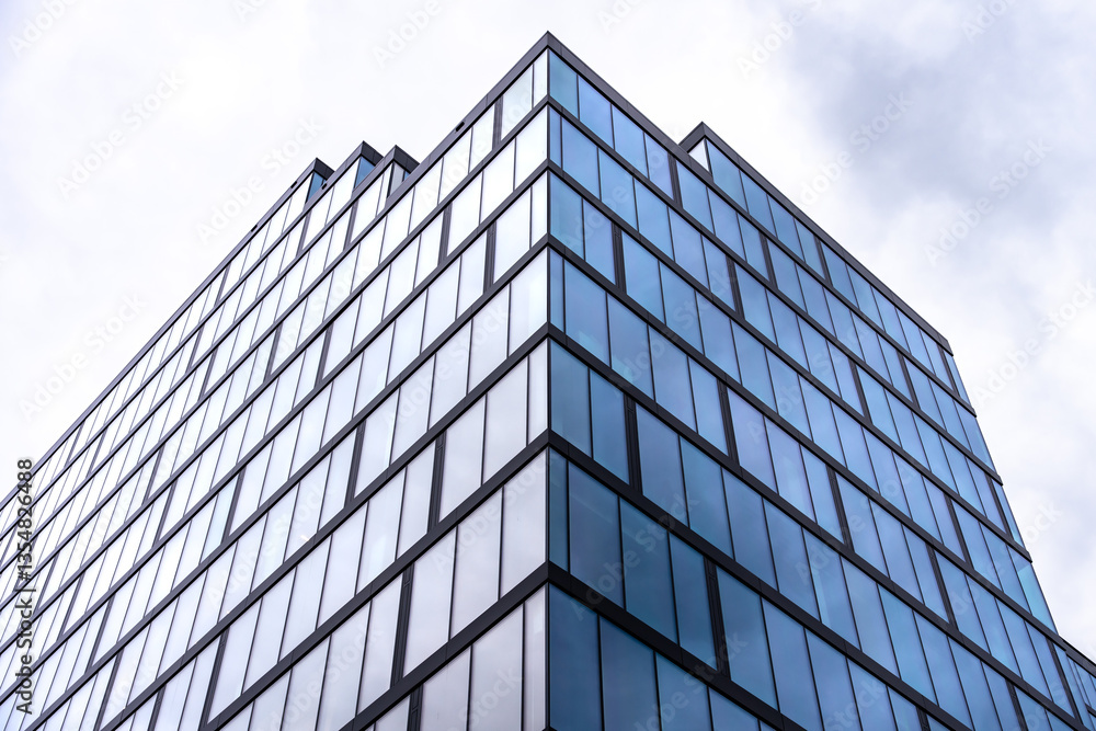 Corner view of glass office skyscraper with geometric window pattern Corner view of glass office skyscraper with geometric window pattern
