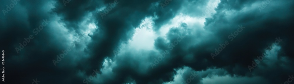 Fototapeta premium Dark moody clouds with bright opening in the sky