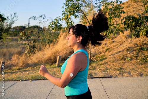 Young Athletic latin Woman with glucose monitor doing exercise