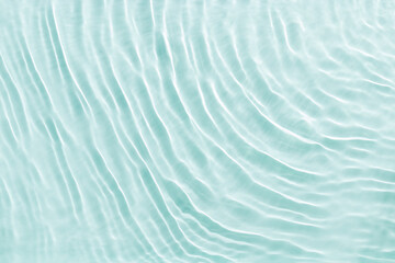 Close up view of sunlit water surface with gentle ripples with light reflections. Crystal clear water with sunlight soft wavy patterns. Abstract nature minimal background, natural textural backdrop