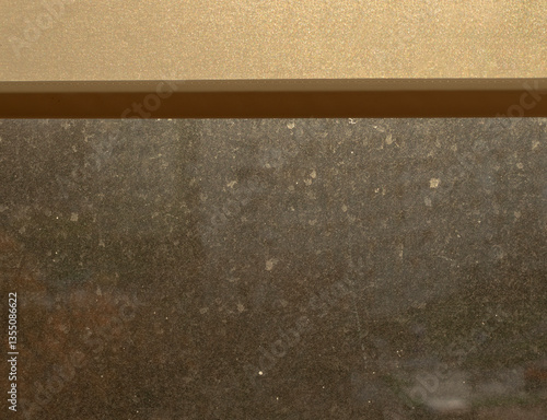 Very Dirty Window Pane In Sunlight. Streaks, Stains And Dust On The Glass Illuminated By The Light Of The Setting Sun. Window Glass Covered With Dirt.