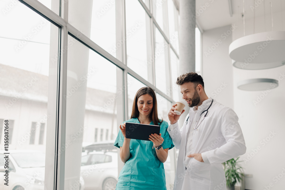 Fototapeta premium Doctors using tablet and drinking coffee during hospital break
