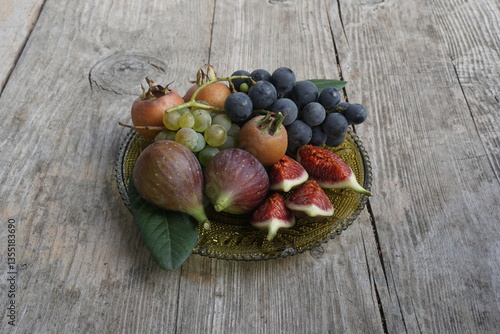 Assorted Fresh Fruits Including Grapes, Figs, and Medlar on a Wooden Plate
