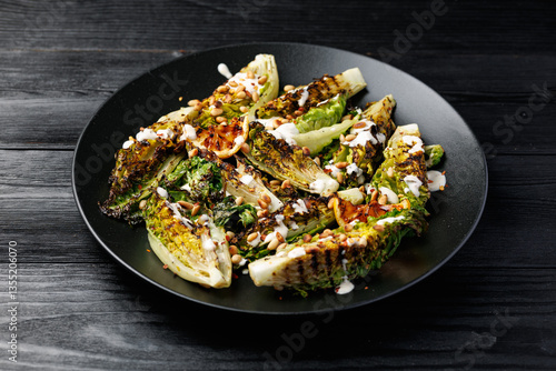 Foto Grilled little gem lettuce with aioli sauce, roasted pine nuts and chilli flakes