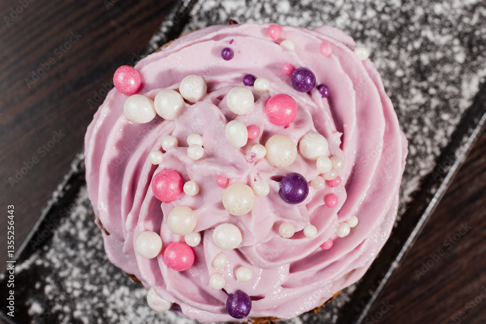 Appetizing fresh dessert cake on a black plate decorated with air cream and cake decorations sprinkled with powdered sugar. sweet dessert from the best confectioner in the city. cream top view