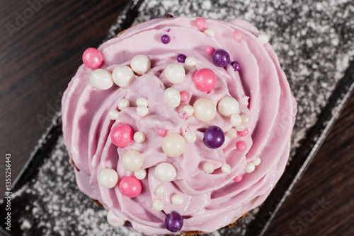 Appetizing fresh dessert cake on a black plate decorated with air cream and cake decorations sprinkled with powdered sugar. sweet dessert from the best confectioner in the city. cream top view