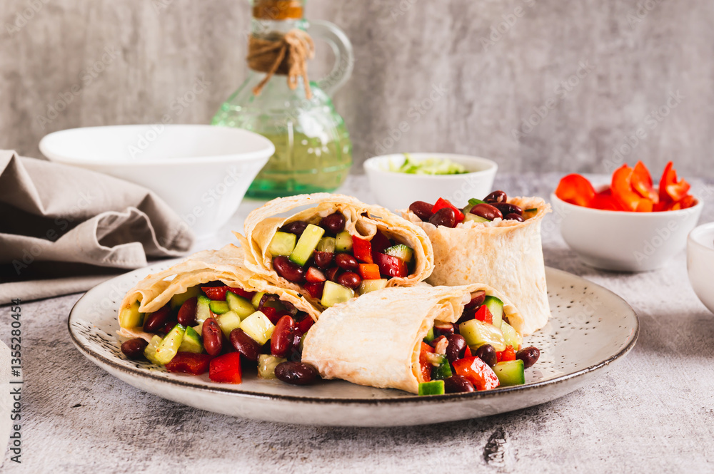 Salad of beans, cucumber and pepper in lavash rolls on a plate on the table