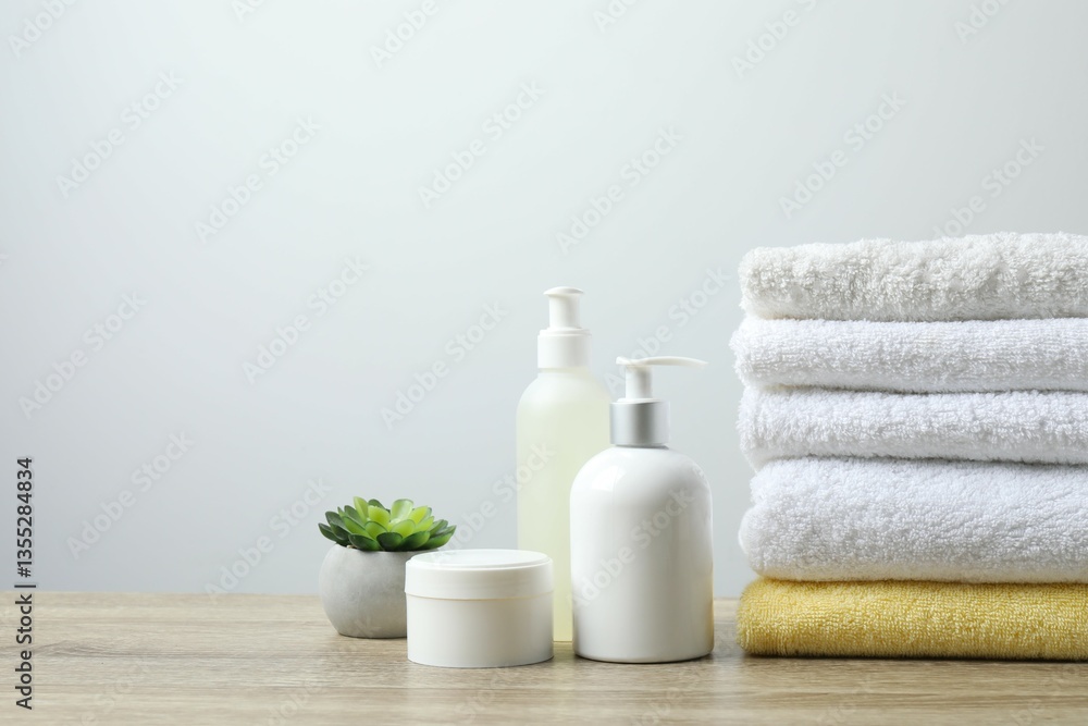 Stack of white towels and cosmetics on the table Stack of white towels and cosmetics on the table