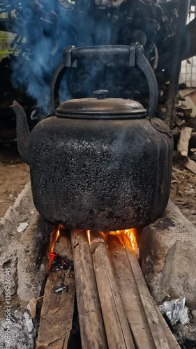 Boiling water using a traditional kettle and stove in the village, fueled by forest wood. Close up of the fire produced from burning wood used to boil water in a black kettle in the traditional way