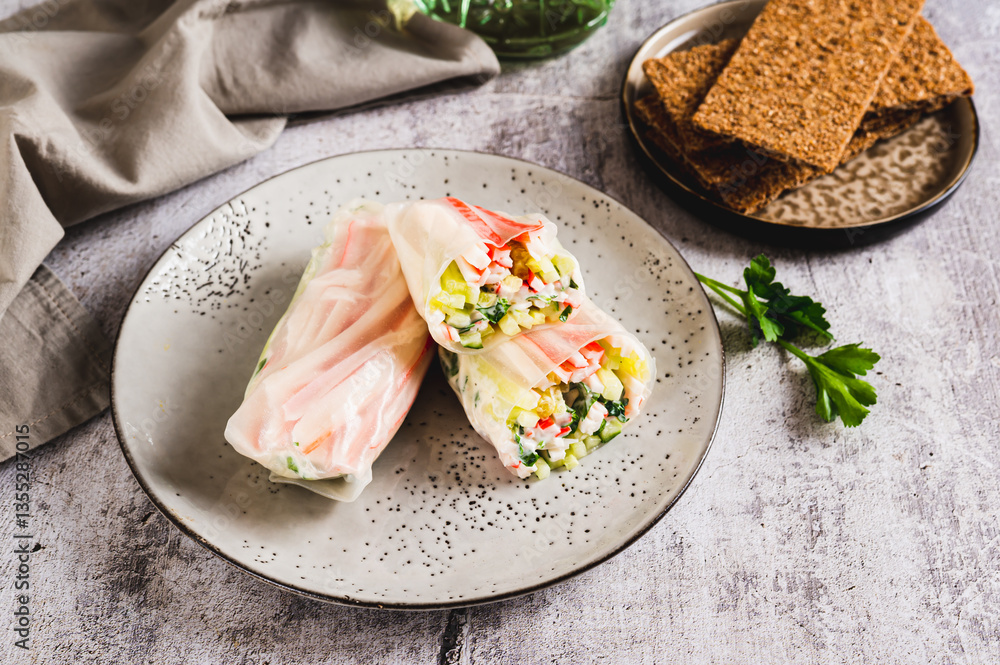 Spring rolls with crab meat, cucumber and herbs on a plate on the table