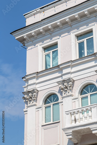 The angle of the facade of the old building that was built 100 years ago against the backdrop of the blue sky. windows on the building