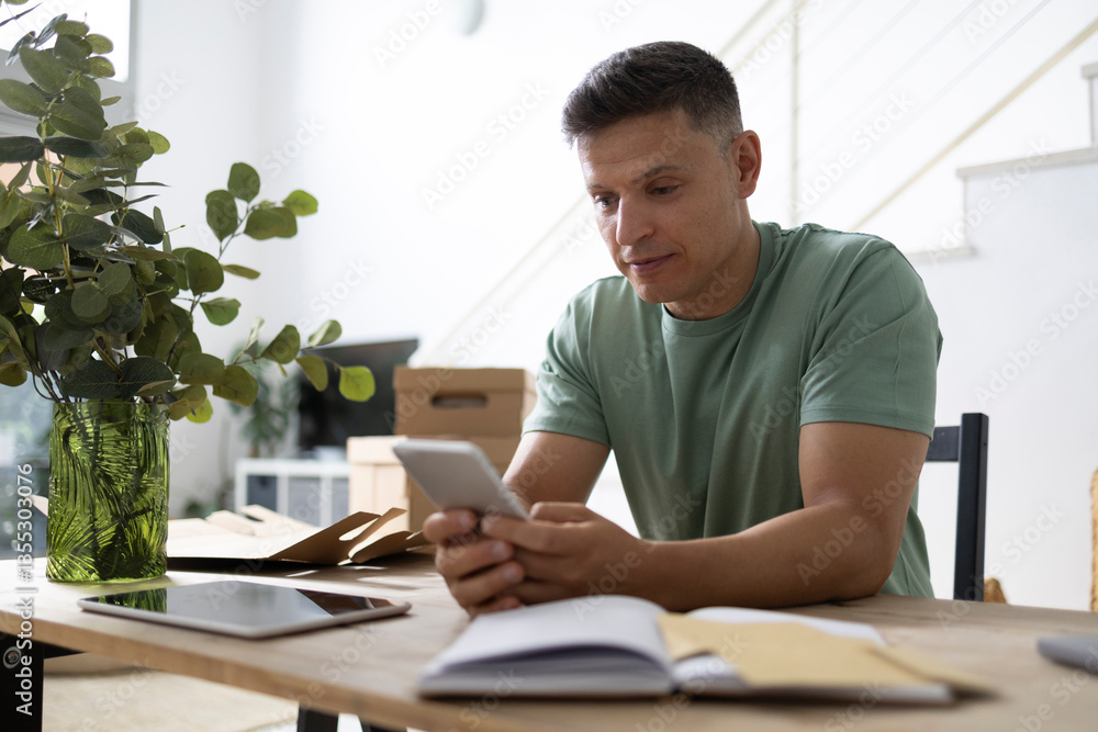 Small business owner using smartphone in his office Small business owner using smartphone in his office
