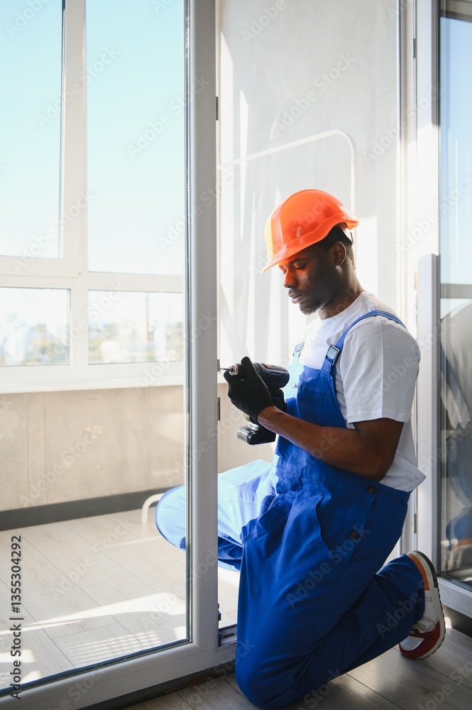 Young African Repairman In Overalls Installing Window Young African Repairman In Overalls Installing Window