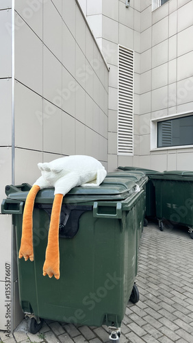 trash can with a soft toy on it. concept childhood is over