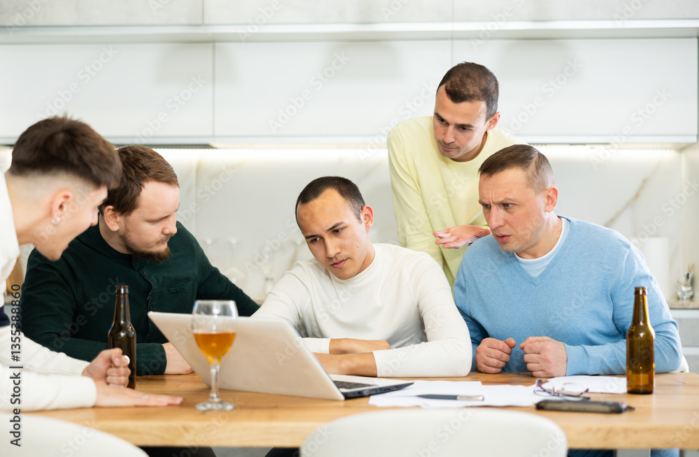 Men drink beer and try to help friend solve problems using laptop and the Internet Men drink beer and try to help friend solve problems using laptop and the Internet