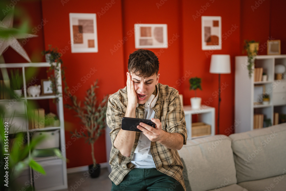 man use mobile smart phone to play video games sit in the living room man use mobile smart phone to play video games sit in the living room