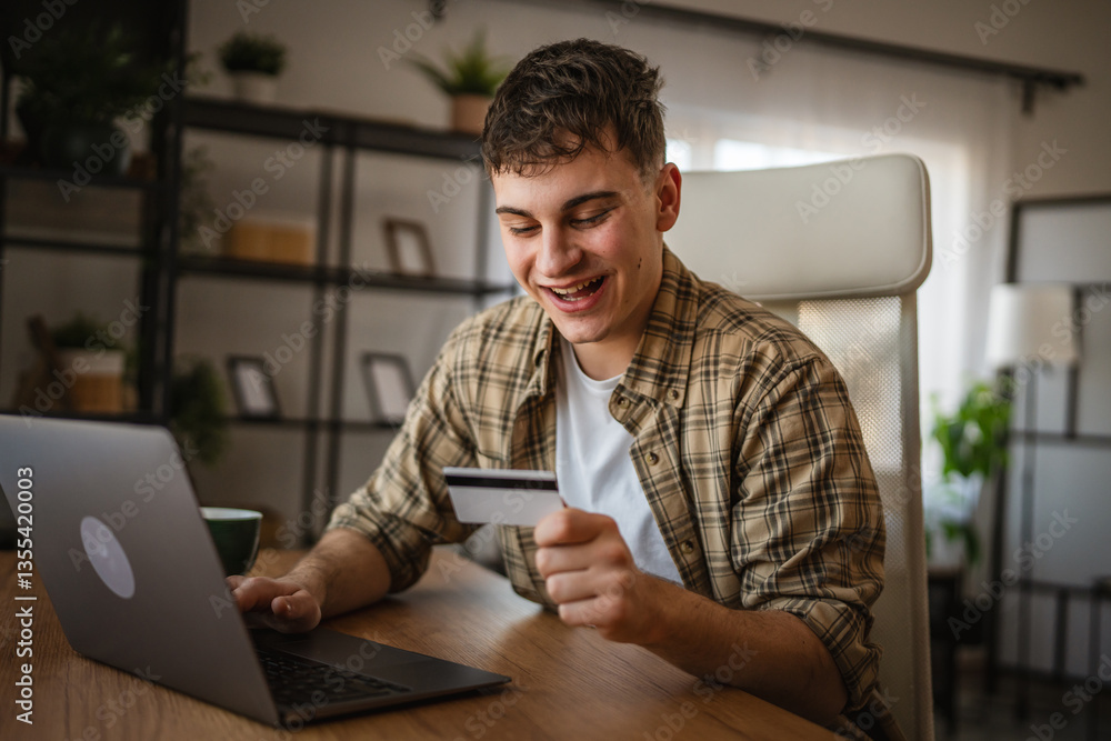 Fototapeta premium young man enjoy at online shopping use credit card and laptop at home