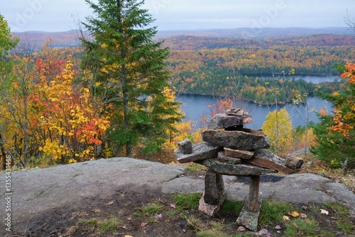 Inukshuk rock structure wit the view to the lake or river in autumn tim