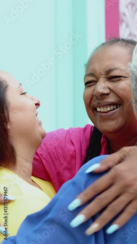 Happy multiracial senior women having fun hugging each other outdoor - Older community lifestyle. Vertical video
