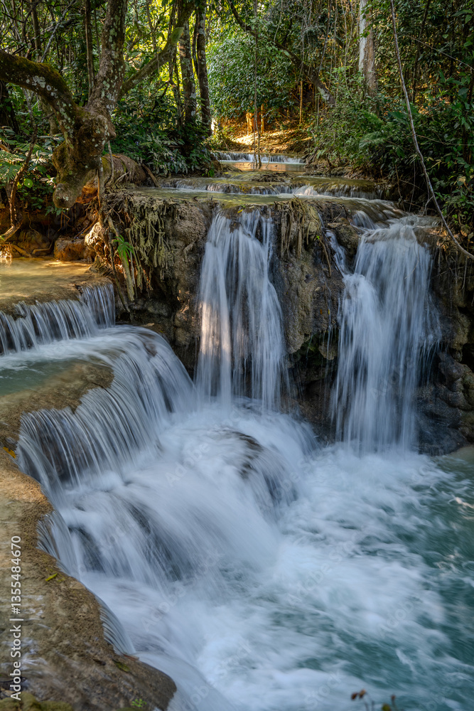 Powerful Multi-Tiered Cascade of Kuang Si Waterfall Surging Through Lush Jungle near Luang Prabang, Laos Powerful Multi-Tiered Cascade of Kuang Si Waterfall Surging Through Lush Jungle near Luang Prabang, Laos