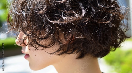 Curly haired woman with trendy short haircut outdoors.