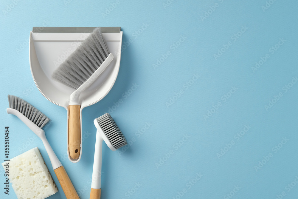Fototapeta premium Household cleaning tools on a bright blue background. Top view dustpan, brush, sponge, and scrub brushes