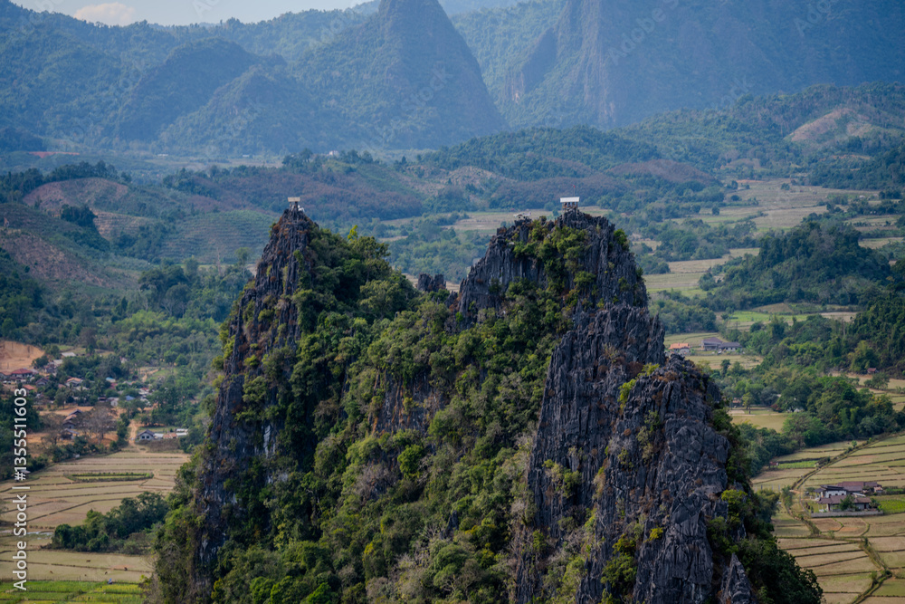 Fototapeta premium Twin Limestone Peaks with Scenic Viewing Platforms Surrounded by Farmlands and Rolling Hills in Vang Vieng, Laos