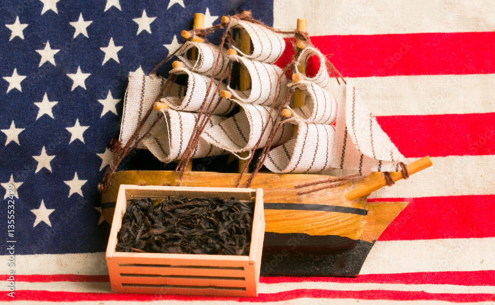 Fototapeta premium ship with a box of tea on the background of the US flag. Boston Tea Party concept