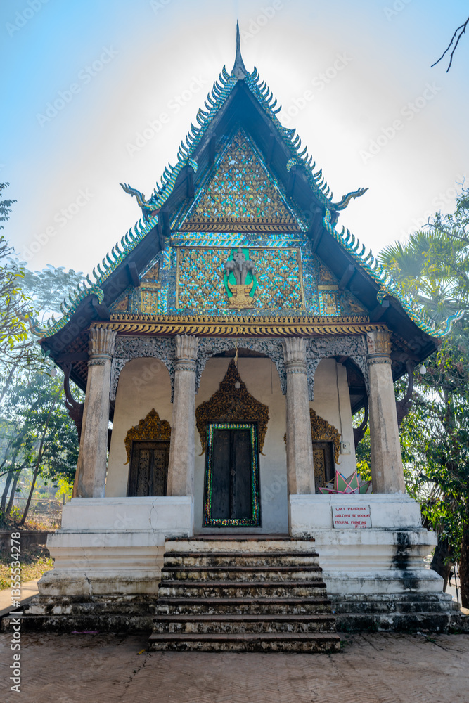 Ancient Buddhist Temple with Ornate Mosaic Façade and Traditional Architecture at Wat Tham Phou Si in Luang Prabang, Laos Ancient Buddhist Temple with Ornate Mosaic Façade and Traditional Architecture at Wat Tham Phou Si in Luang Prabang, Laos