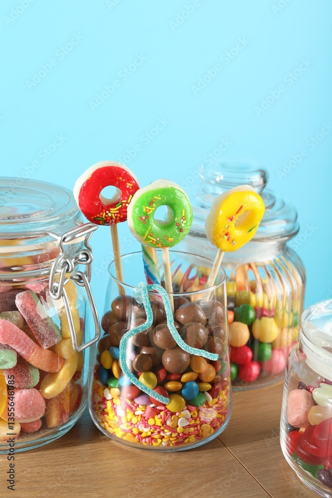 Fototapeta premium Candy bar. Many different sweets on wooden table against light blue background, closeup