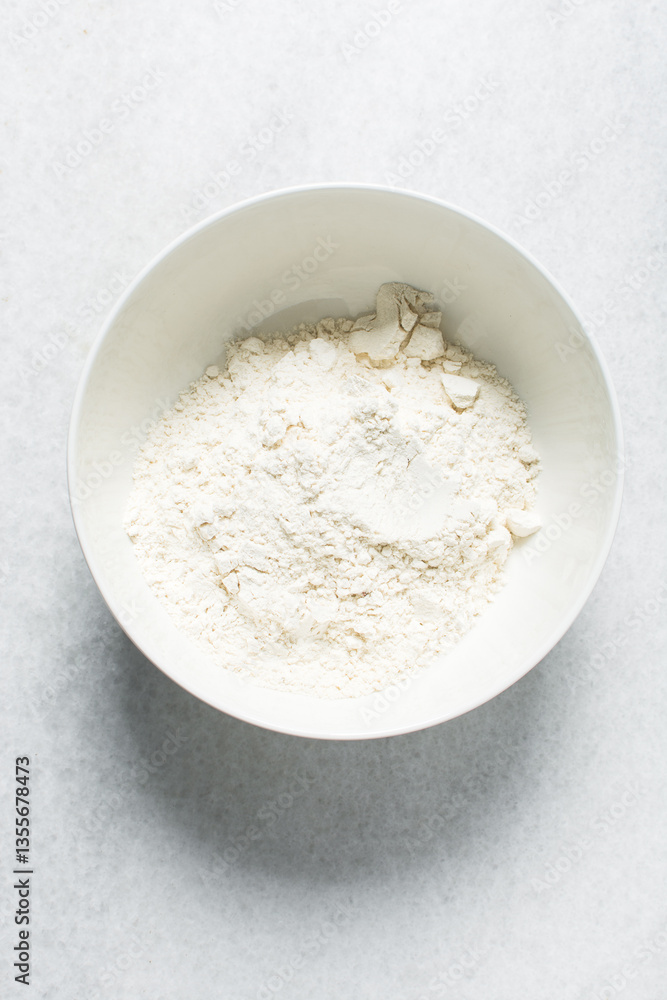 overhead view of All purpose flour in a bowl, top view of baking flour in a ceramic bowl overhead view of All purpose flour in a bowl, top view of baking flour in a ceramic bowl