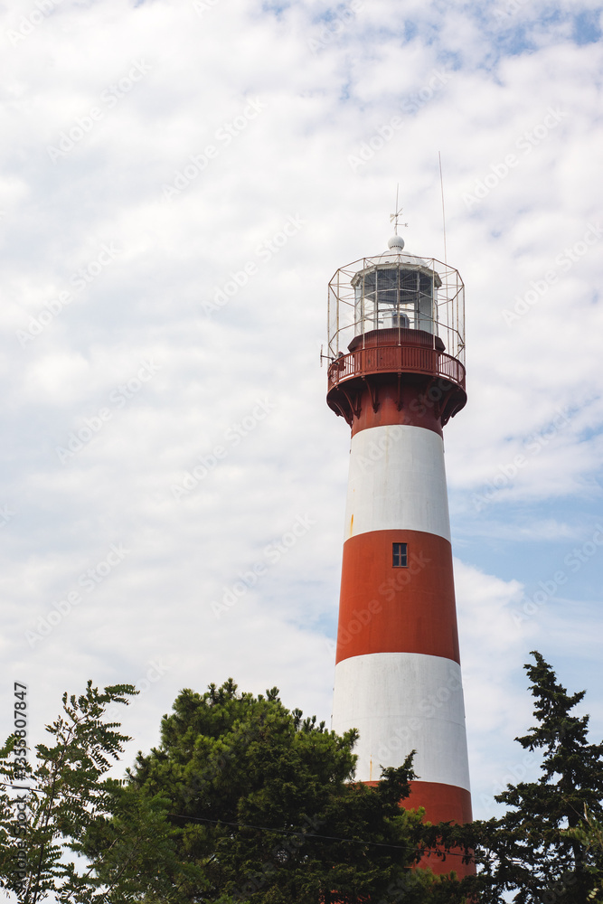 Red and white lighthouse on a background of blue sky with clouds in Poti, Georgia. Red and white lighthouse on a background of blue sky with clouds in Poti, Georgia.