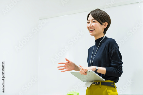 会議室でプレゼンをする30代日本人女性