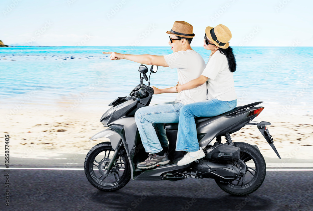 Fototapeta premium Happy Couple Riding Scooter Along Beachside Road on Vacation