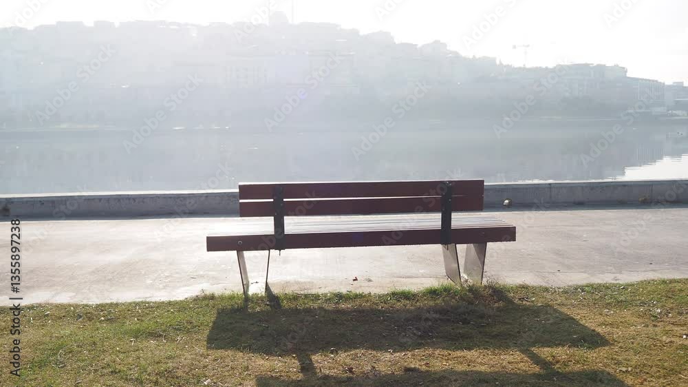 Tranquil lakeside bench with foggy morning reflections Tranquil lakeside bench with foggy morning reflections