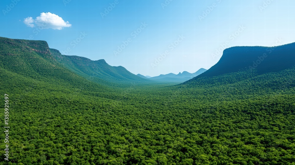 Obraz premium Breathtaking mountain range against a clear blue sky with few fluffy clouds floating above the peaks
