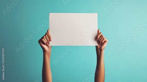 Blank protest sign held high against teal backdrop