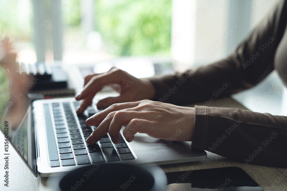 Obraz premium Business woman in casual dress working on laptop computer at home office. Close up, woman online working, surfing the internet, typing on laptop on office table, remote work, side view