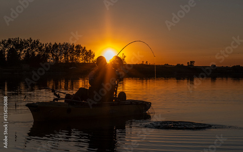 Man catching big fish at sunset